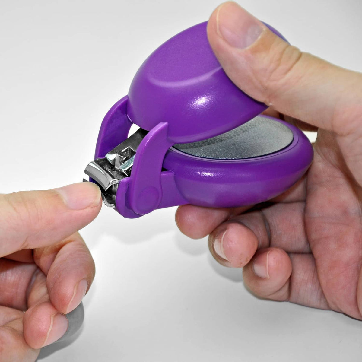 Purple nail clipper close-up with metal blades and safety guard lever