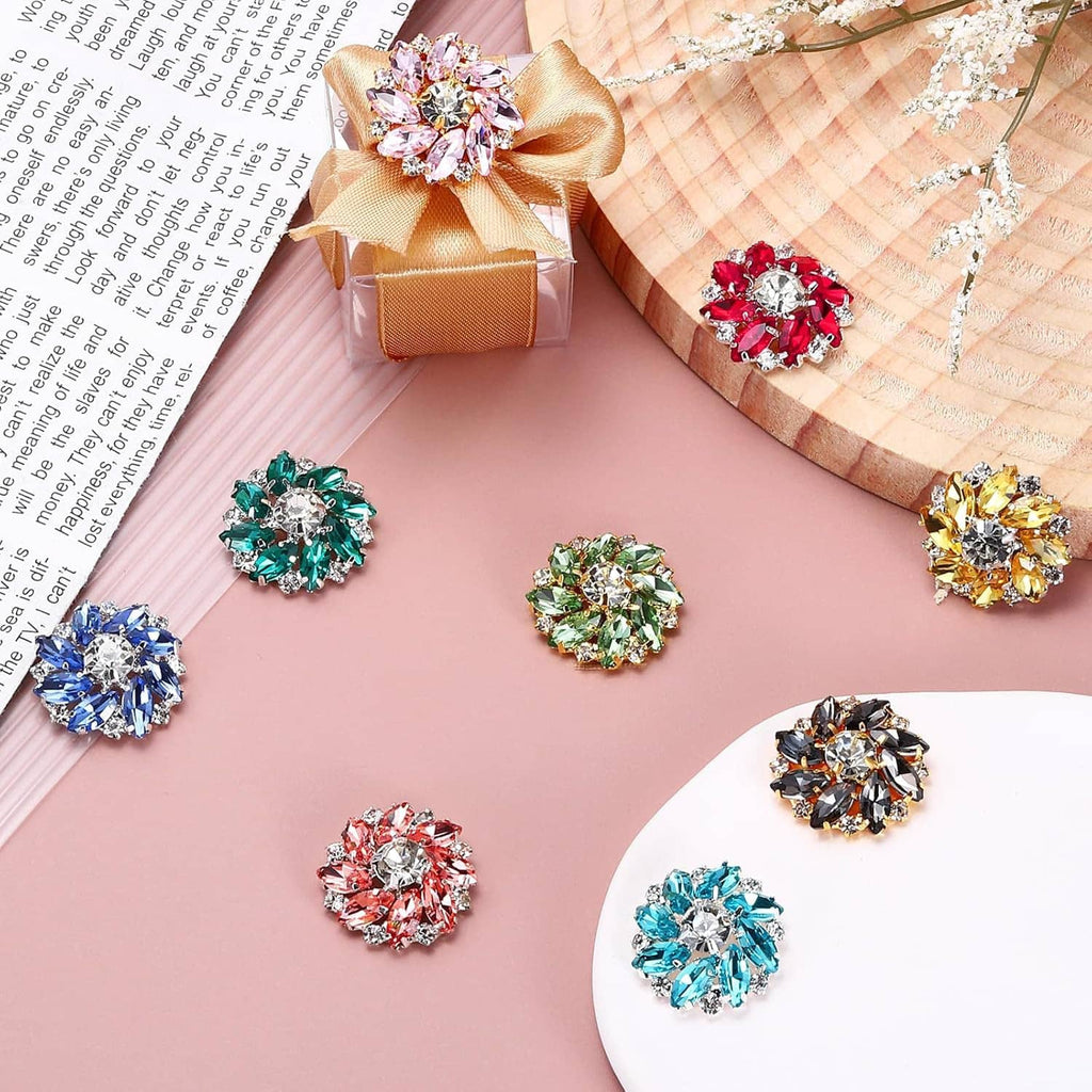 Assorted crystal flower shank buttons scattered on fabric with ribbon and bow