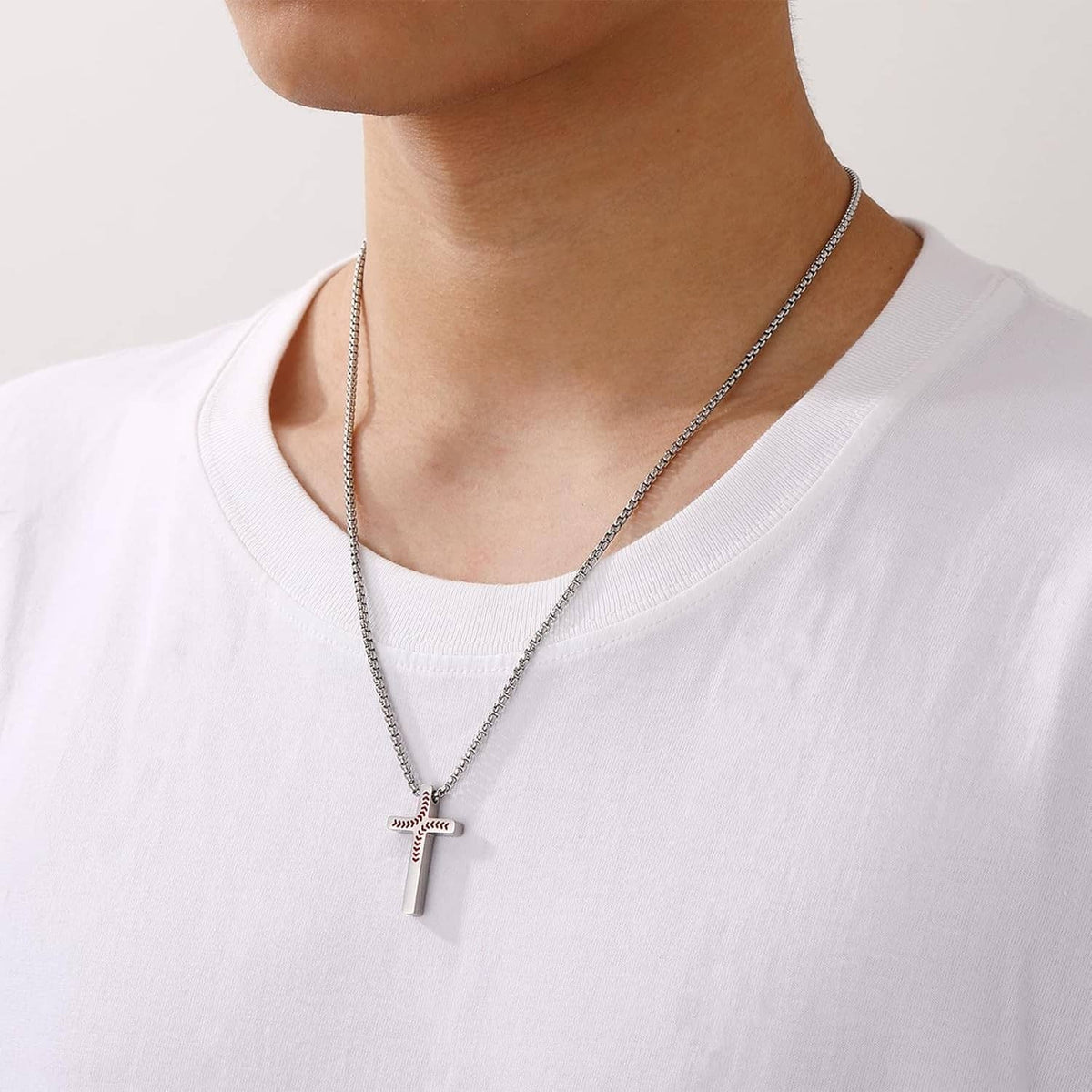Silver chain necklace with small baseball cross pendant on neckline