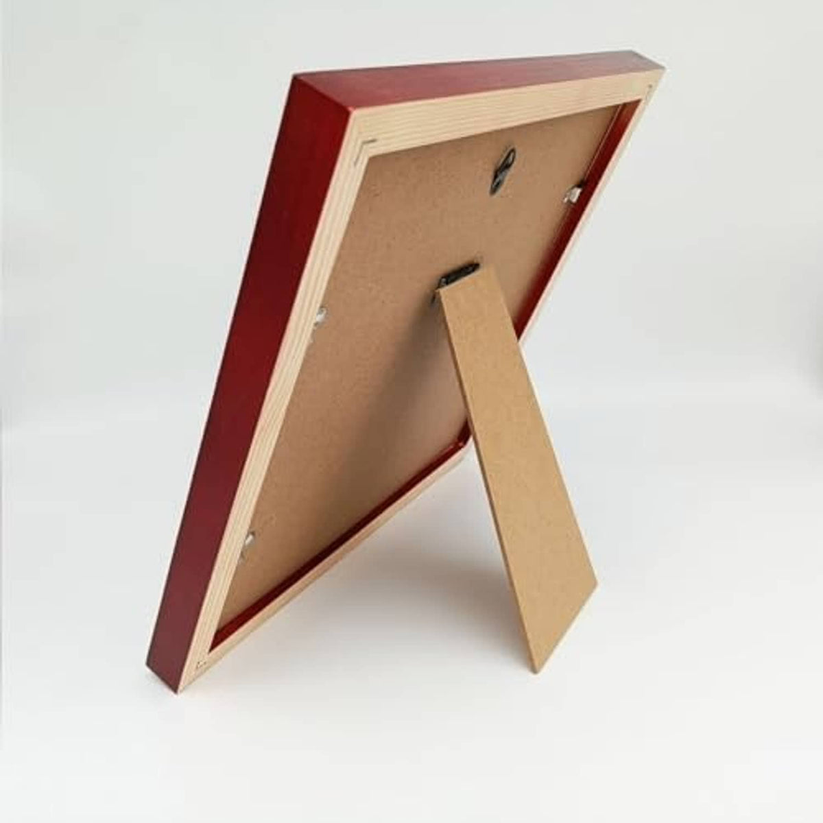Back of red wood picture frame with fold-out stand and brown backing