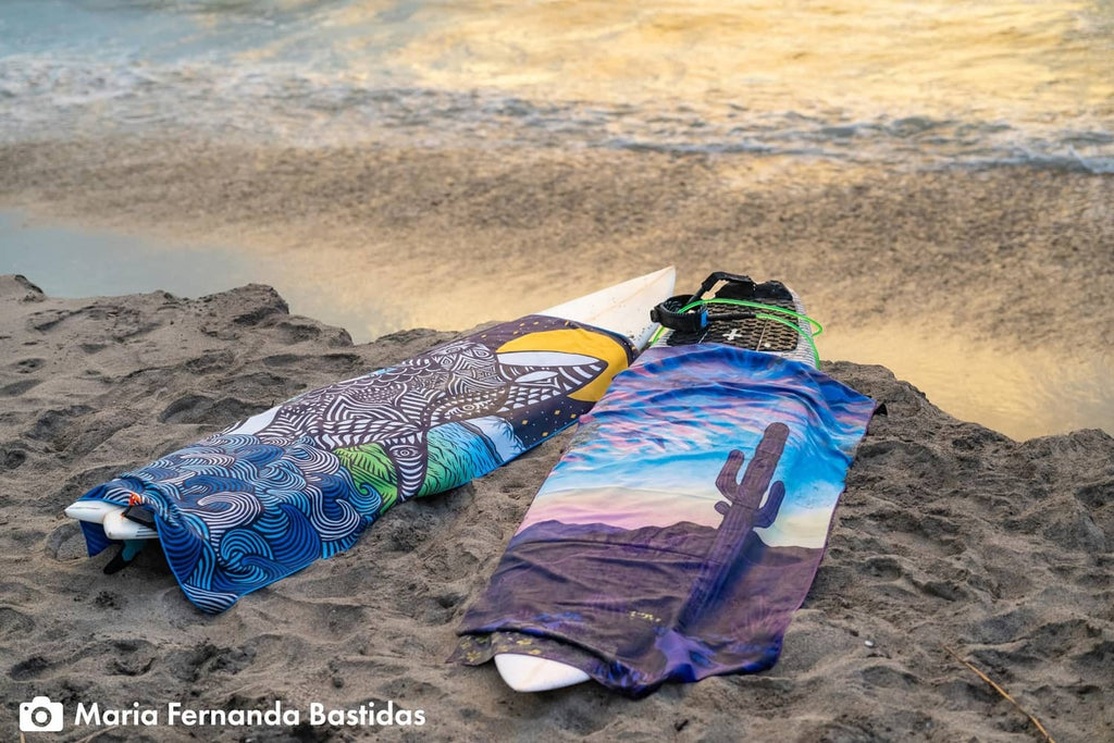 PackTowl ultralight body towels in Desert Aire print, laid flat on sand.