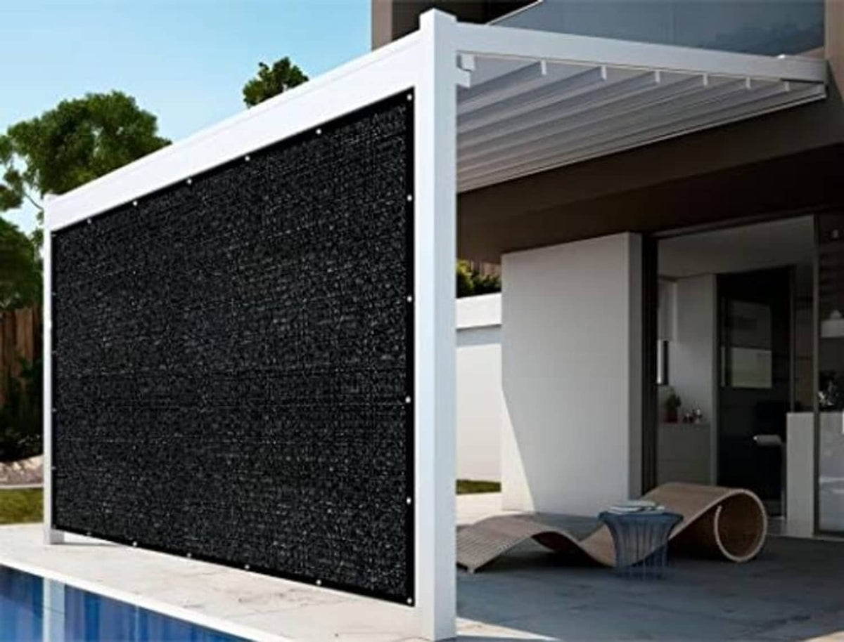Rectangular black shade cloth panel attached to an outdoor pergola frame