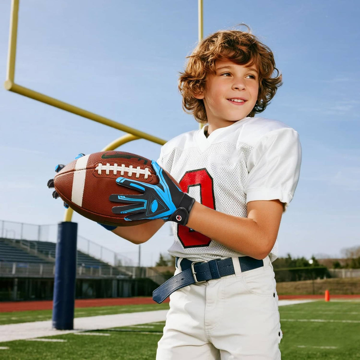 Youth football receiver gloves in black and blue on a football, showing finger grip
