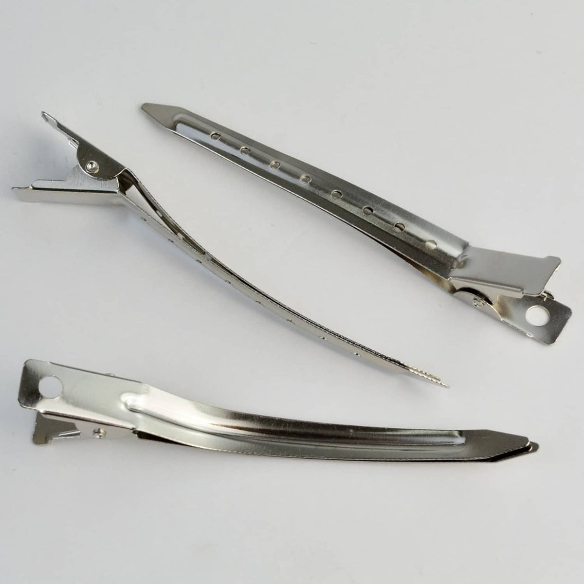 Metal duck-bill clips, two shown side by side with pivot hinge and latch