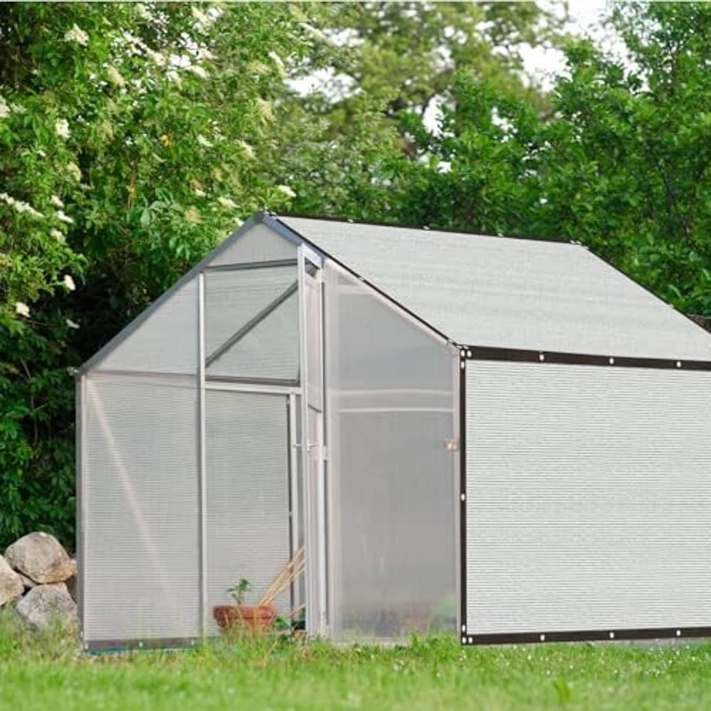 Backyard greenhouse covered with light gray mesh shade cloth roof and side panels