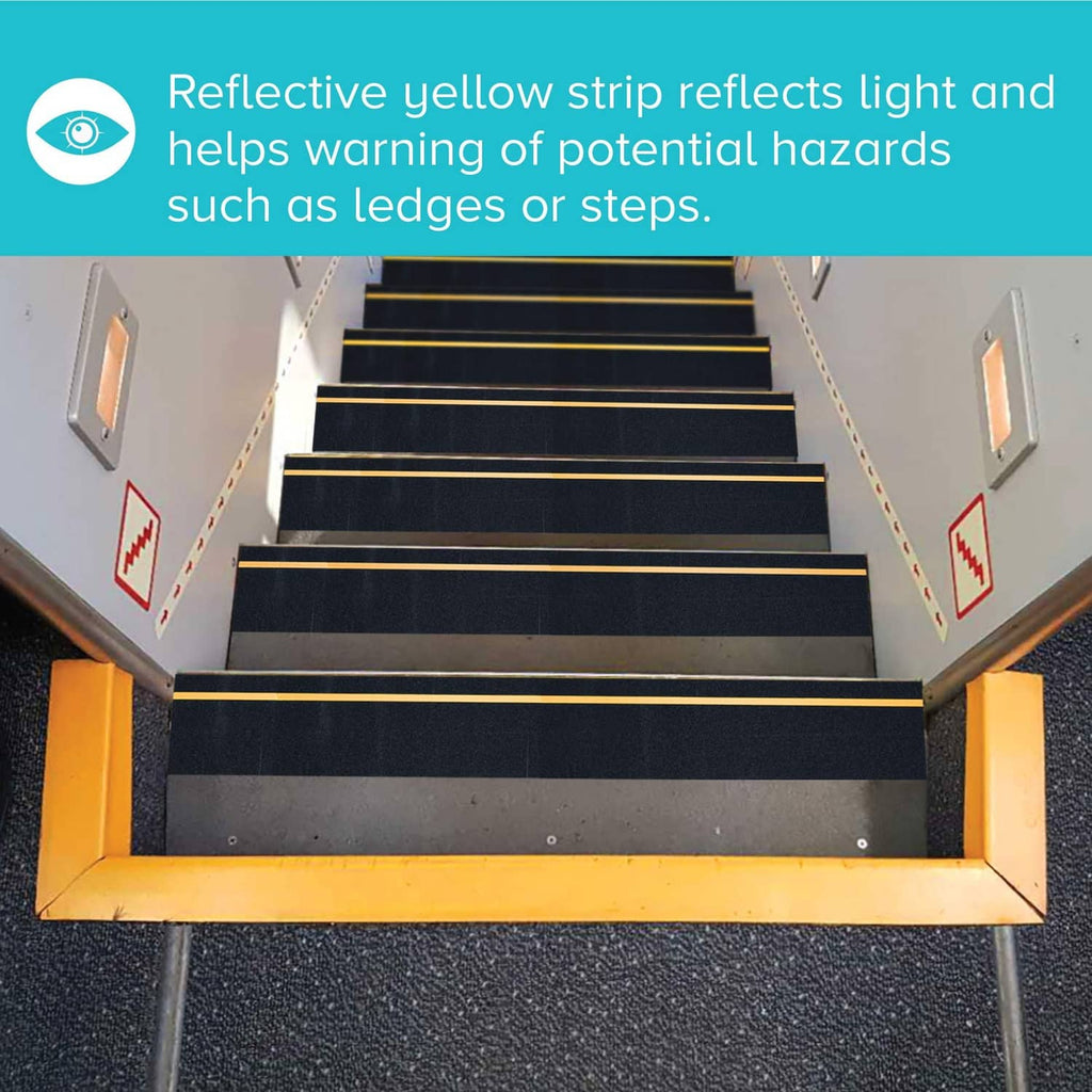 Anti-slip tape on stair treads, black with yellow reflective strip across each step