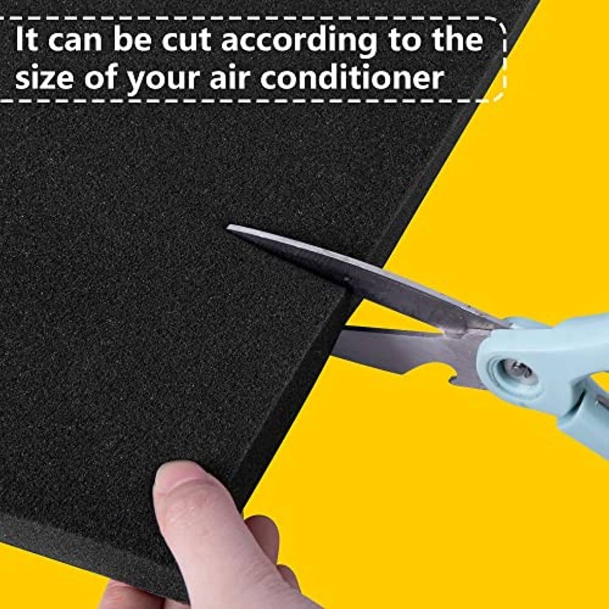 Black AC drip cushion mat being cut with scissors to match air conditioner size.