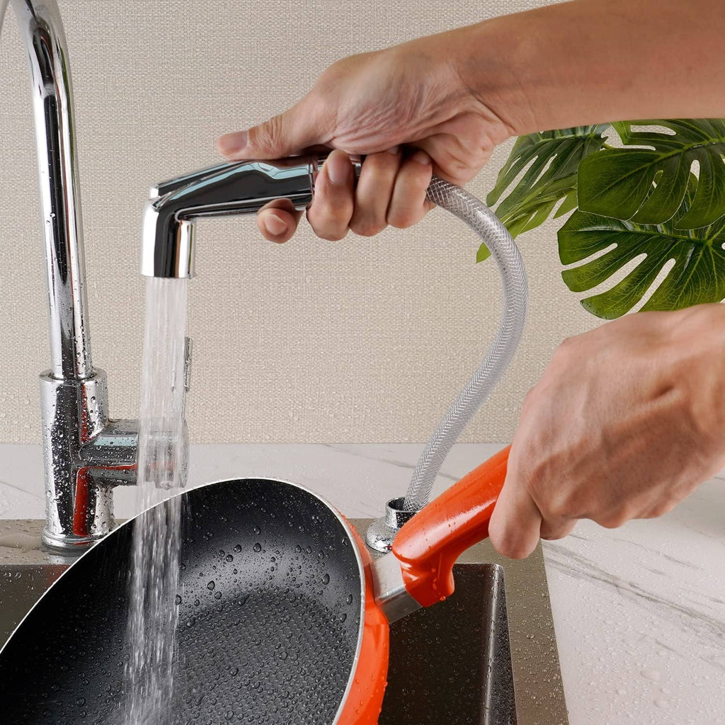 Chrome sprayer head rinsing near sink with water spray stream