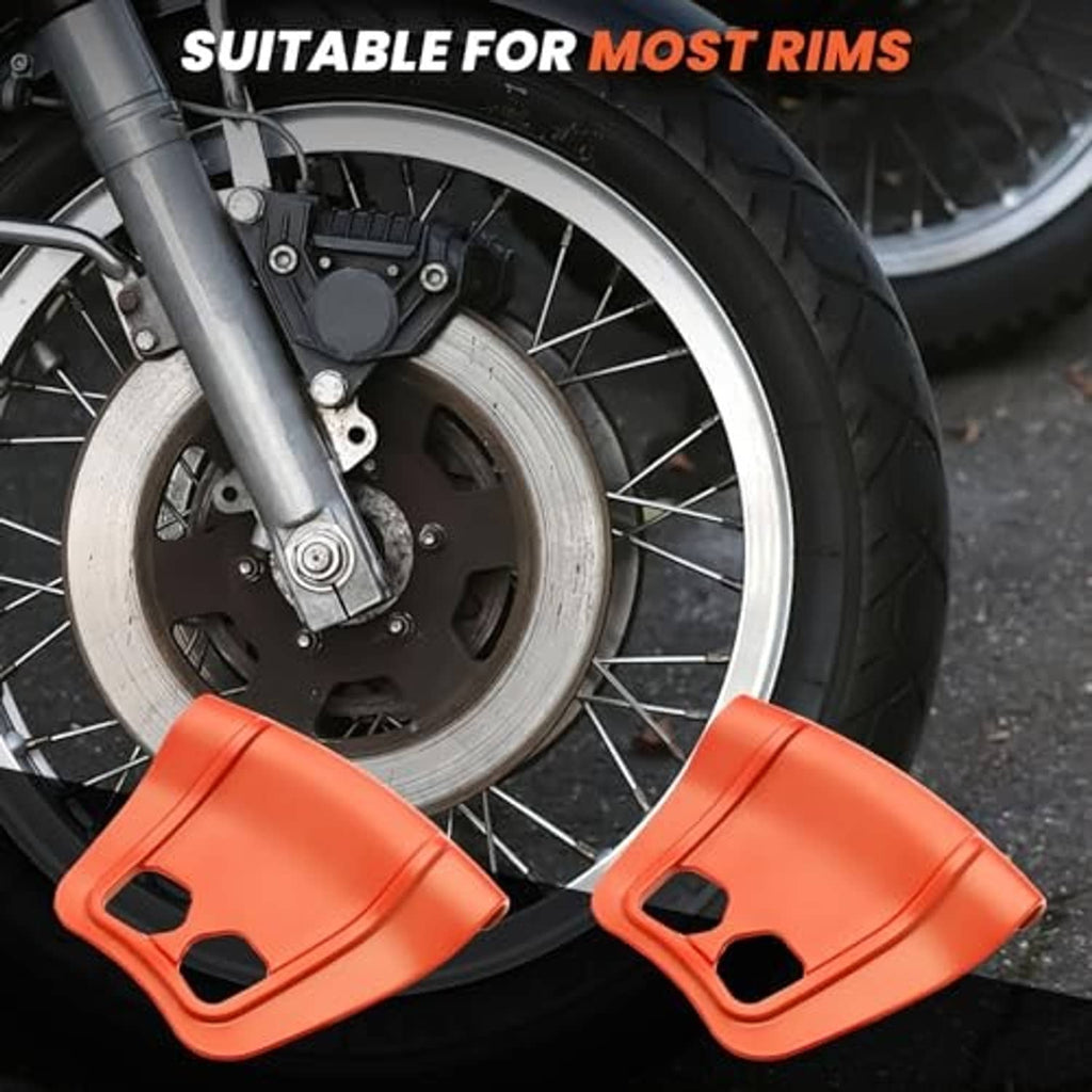 Two orange rim protectors placed on a motorcycle wheel rim side-by-side
