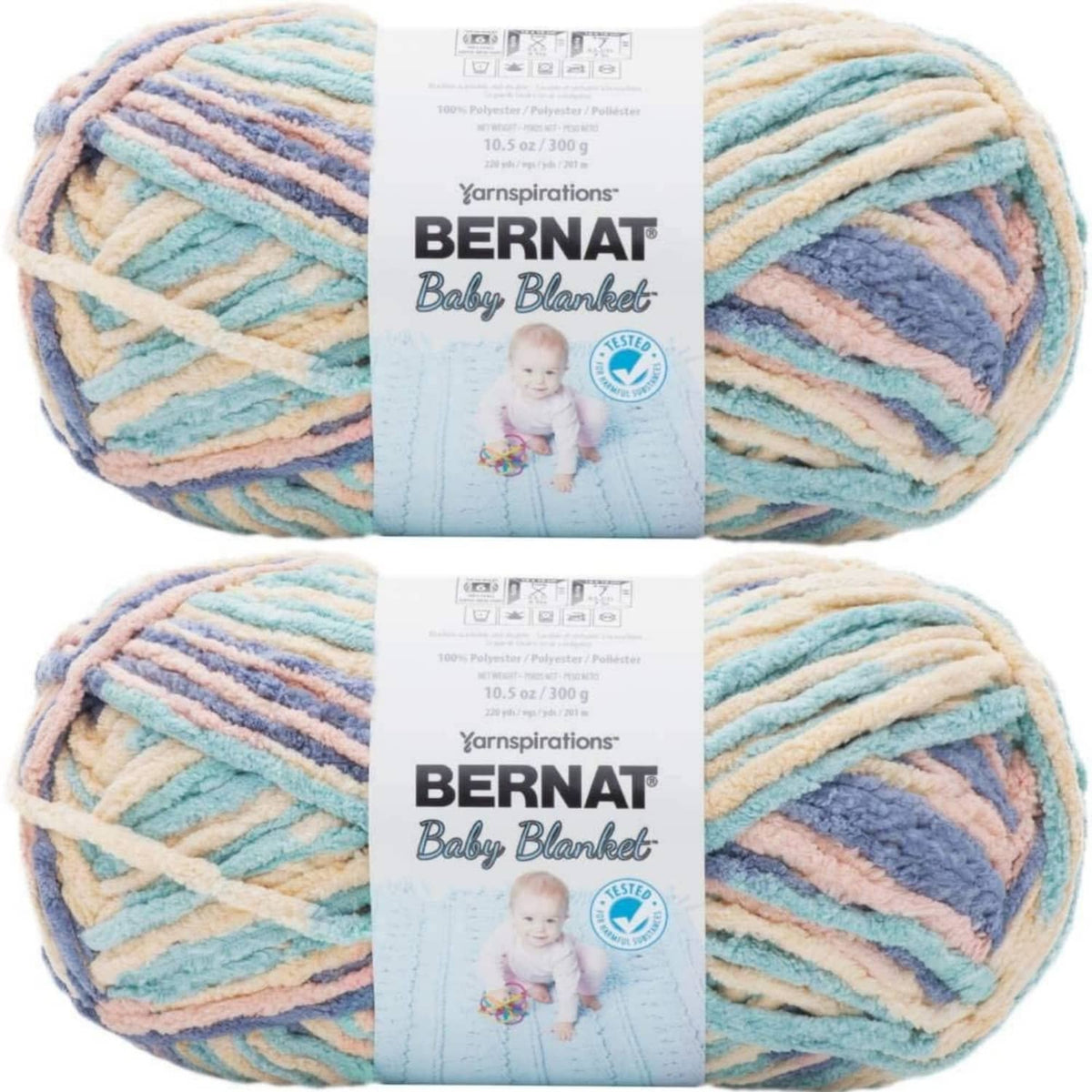 Soft baby blanket yarn skein in pastel stripes of blue, cream, and peach