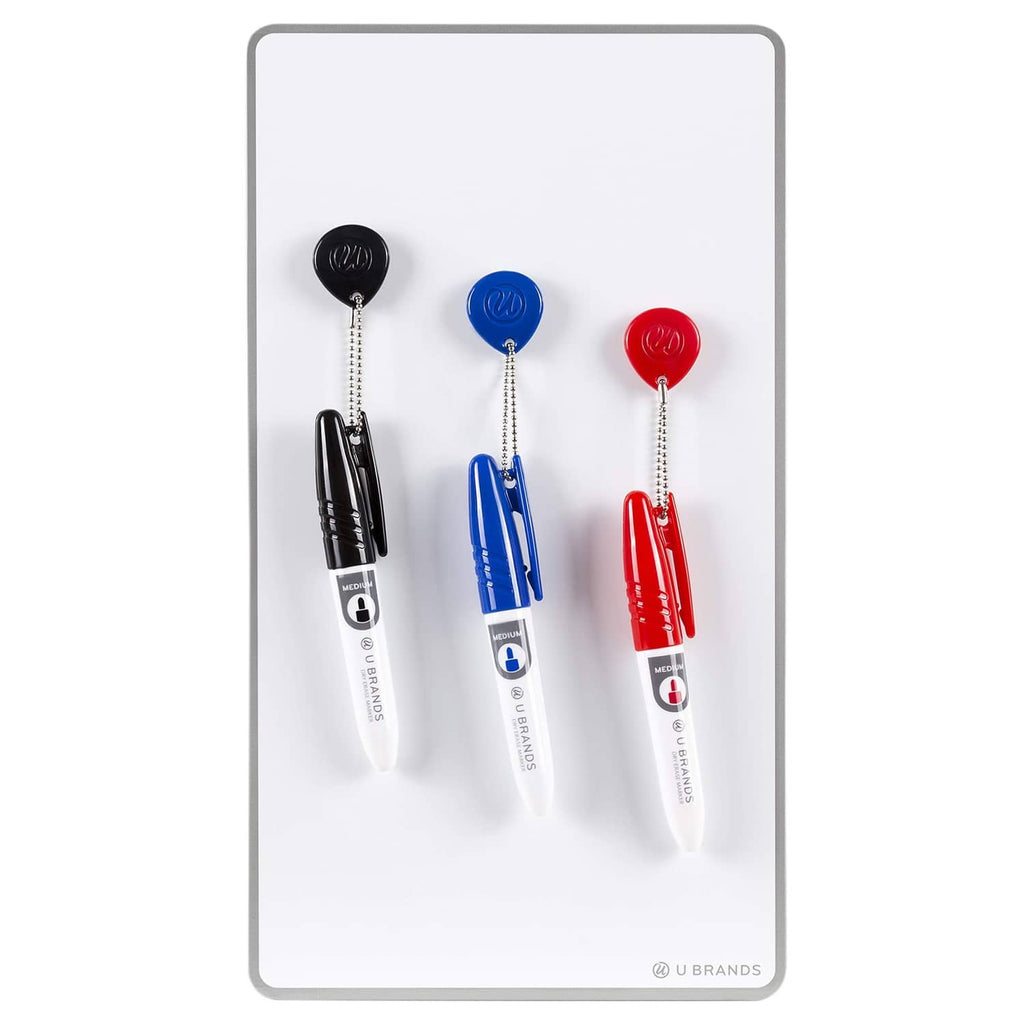 White magnetic dry erase board with three markers: black, blue, red