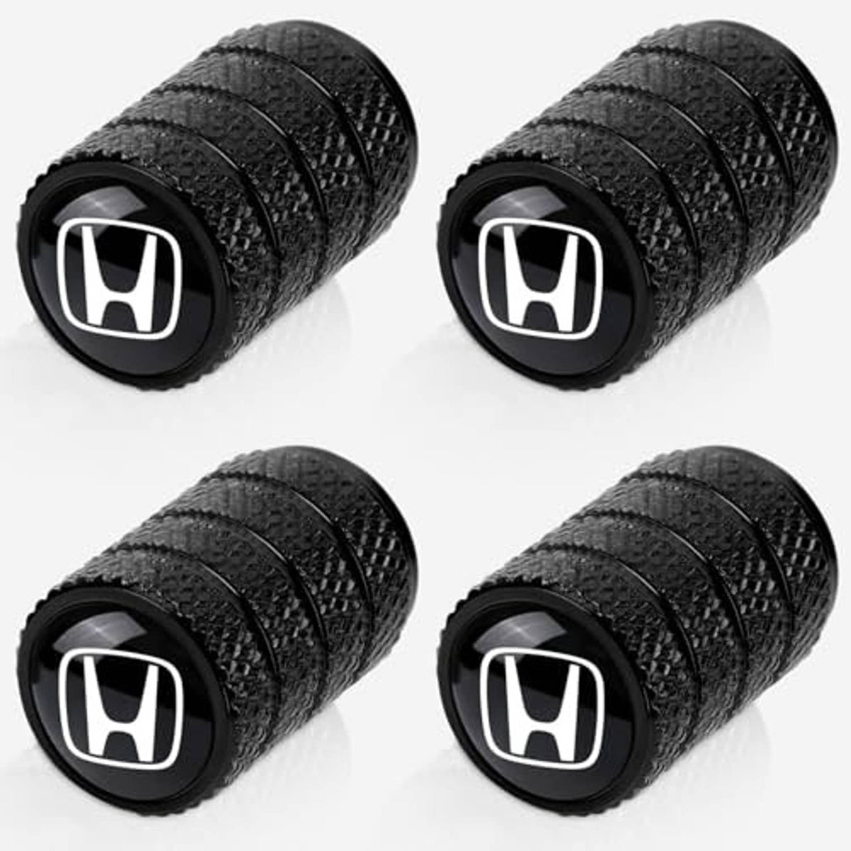 Four-pack black tire valve stem caps with white Honda emblem, angled view