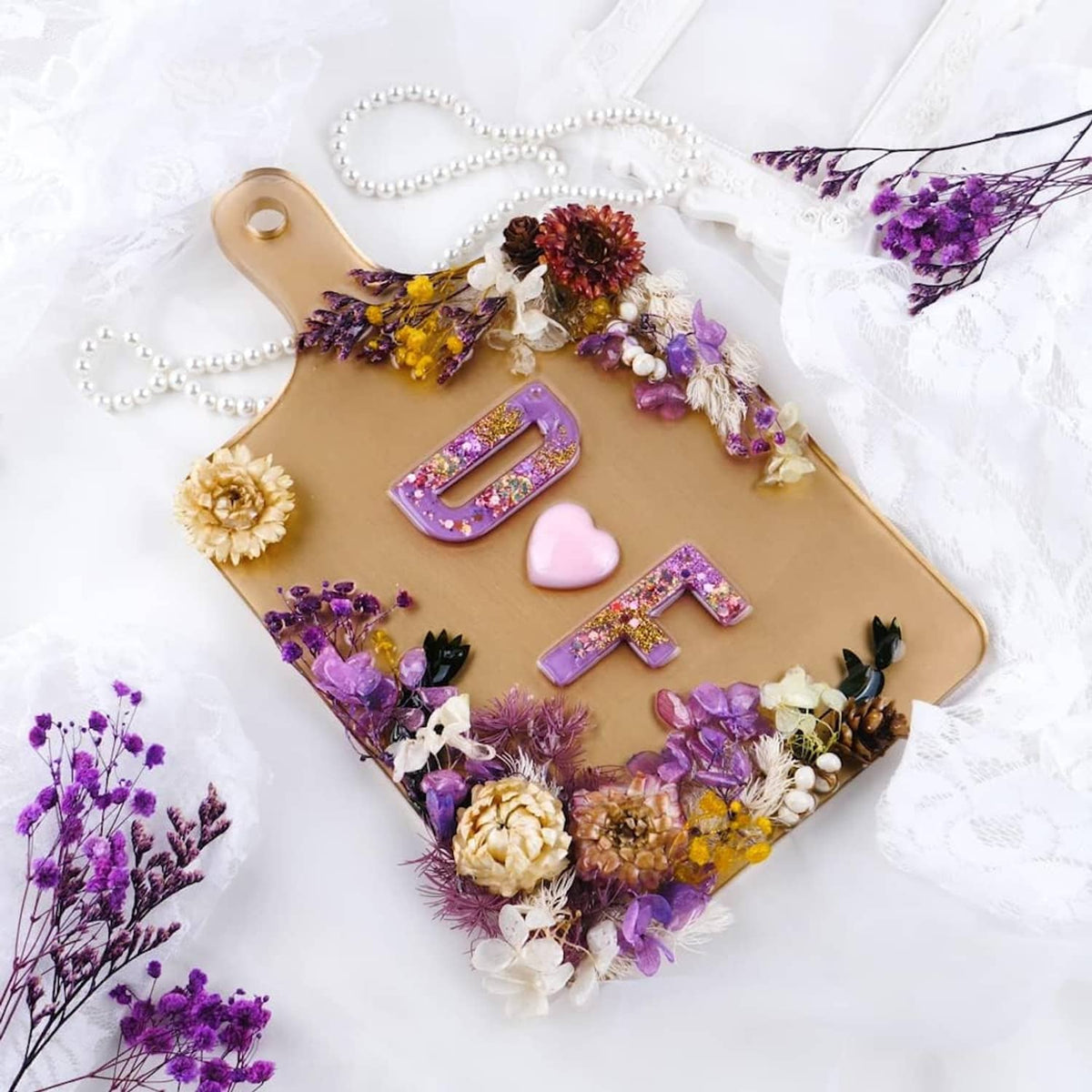 Rectangle resin tray mold filled with floral decorations and purple resin letter cutout