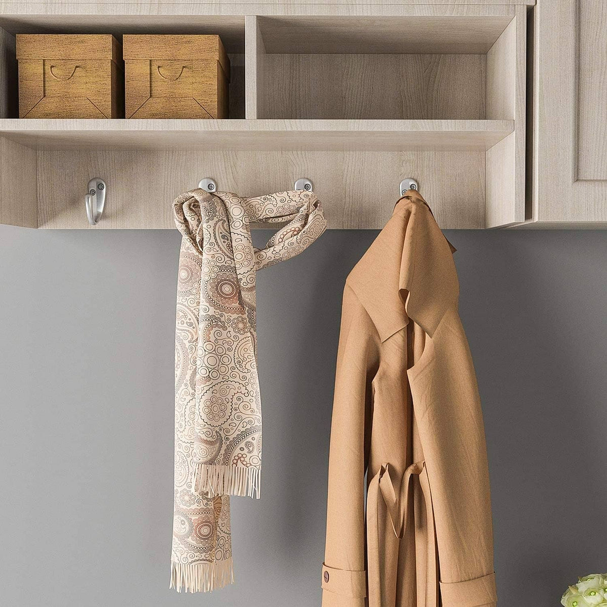 Wall-mounted single-prong coat hooks holding two hanging towels, silver
