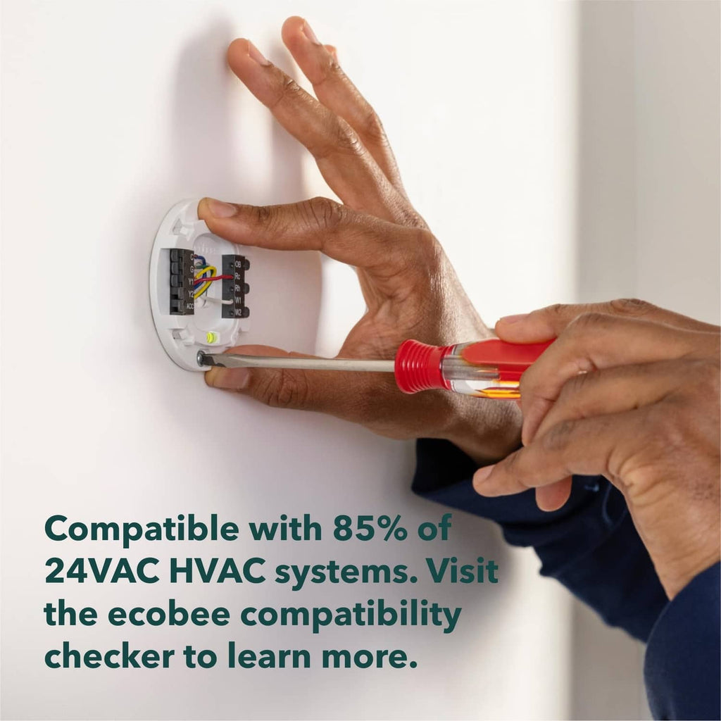 Technician installing a white thermostat on a wall wiring base