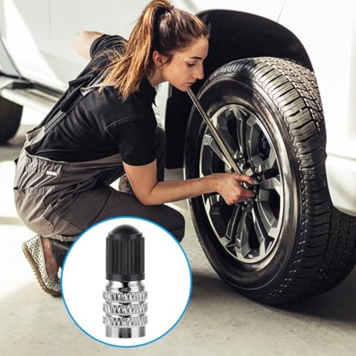 Metal valve stem extension cap with black top being installed near a car wheel