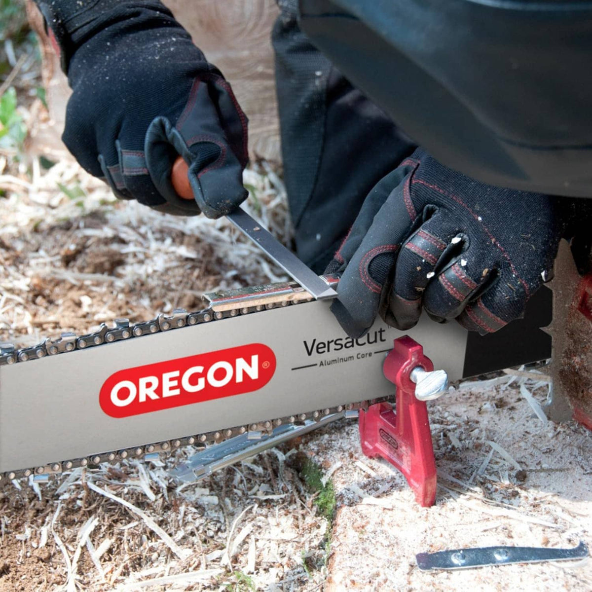 Chainsaw chain sharpening outdoors with Oregon Versacut guide and file tool on chain