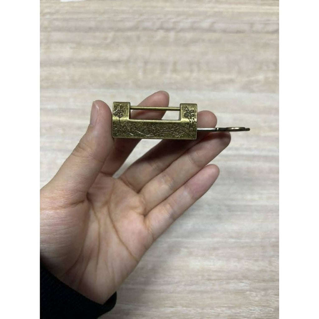 Bronze bird-and-flower padlock shown from the side with matching key