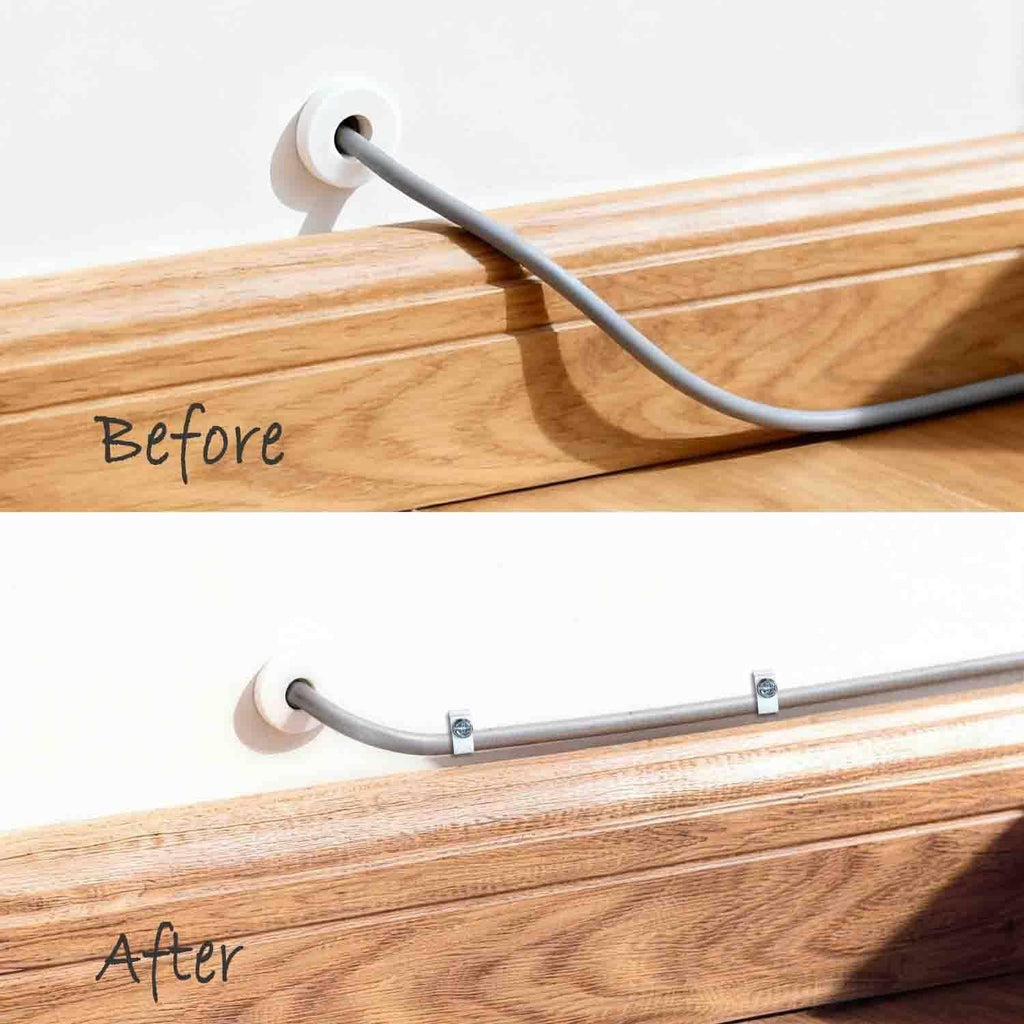 White round cable clips securing a gray cable to wooden board