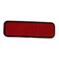 Red rear bumper reflector with textured lens and dark rounded trim, rectangular shape