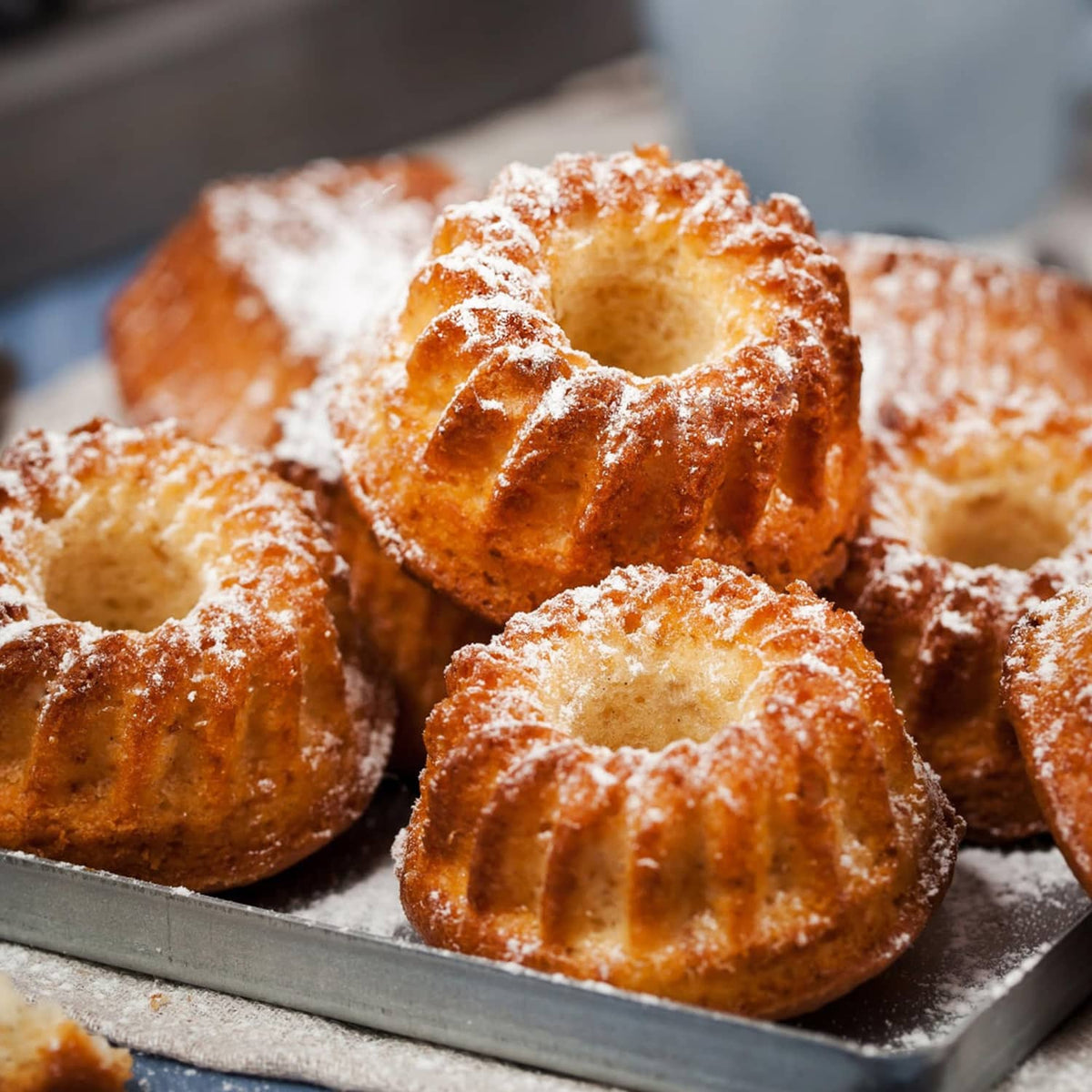 Fluted tube cakes baked in a six-cavity mini pan, golden with sugar dust