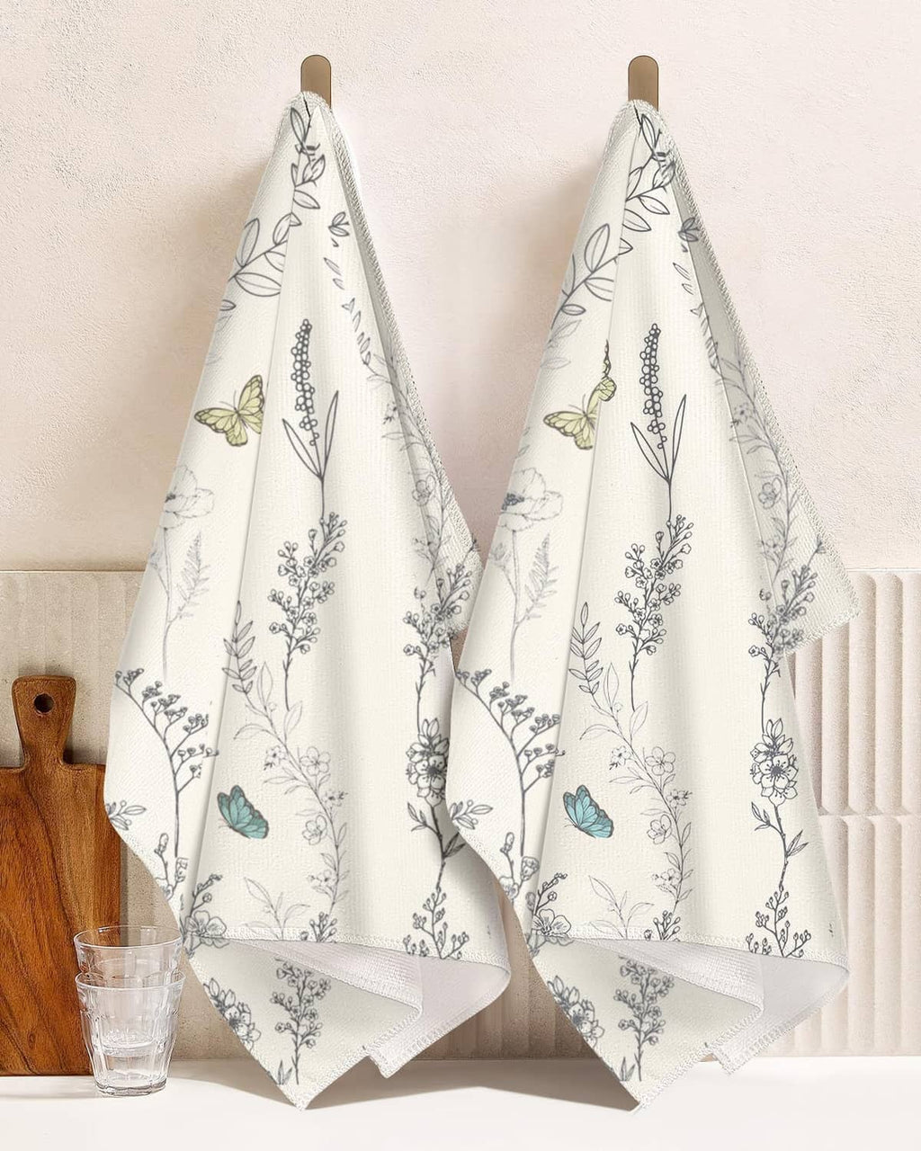 White kitchen towels set of 2 with botanical sprigs and butterfly motifs, hanging