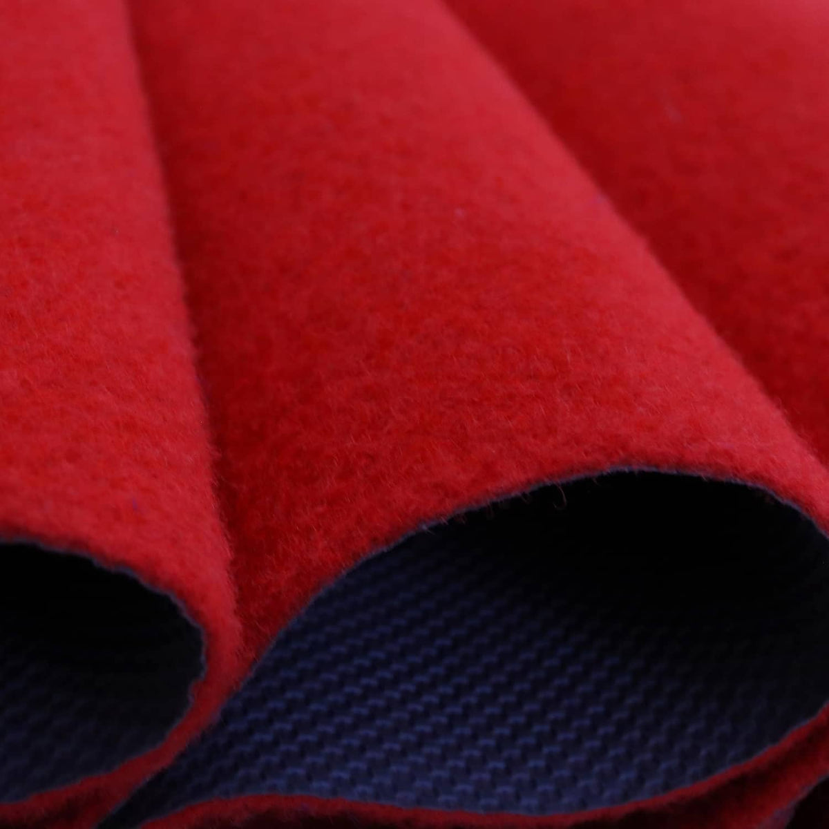 Red carpet runner close-up showing thick pile edge and dark non-slip backing