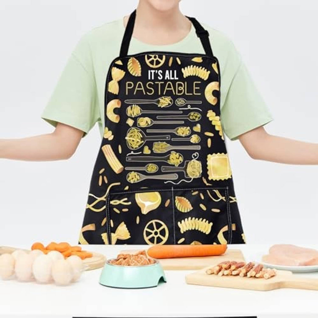 Black pasta graphic apron with 'IT'S ALL PASTABLE' text on a person