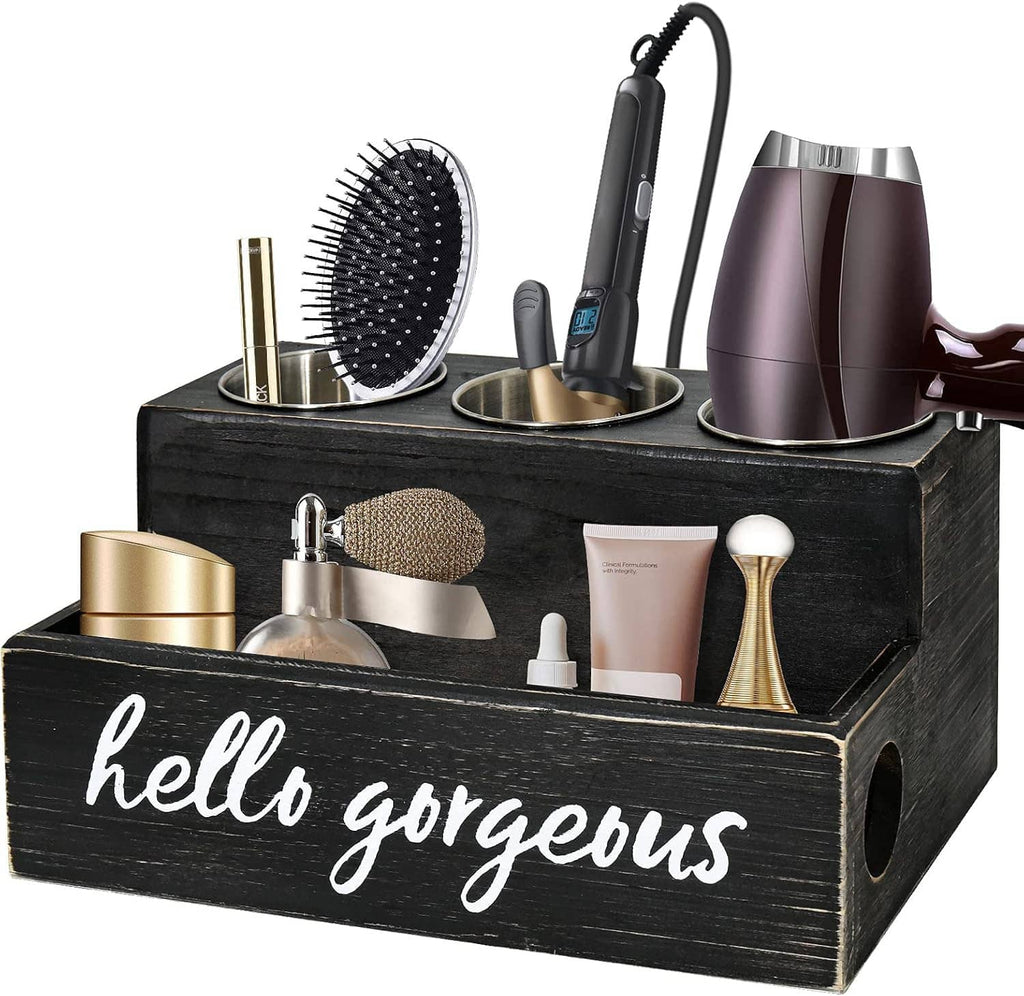 Black countertop hair tool caddy with brushes, blow dryer, and gold-capped jars