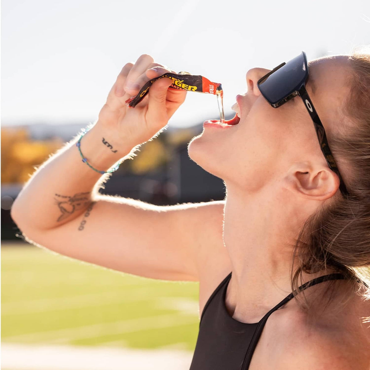 Honey Stinger salted caramel latte caffeinated gel packet near athlete’s mouth
