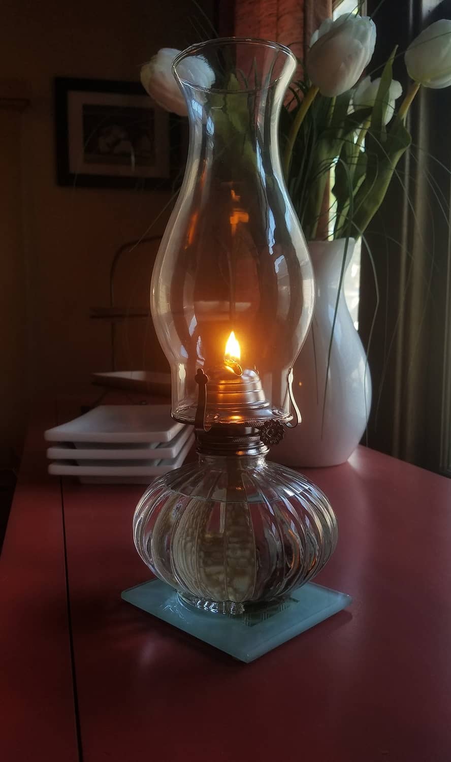 Glass oil lamp with flame, clear lamp oil reservoir and burner