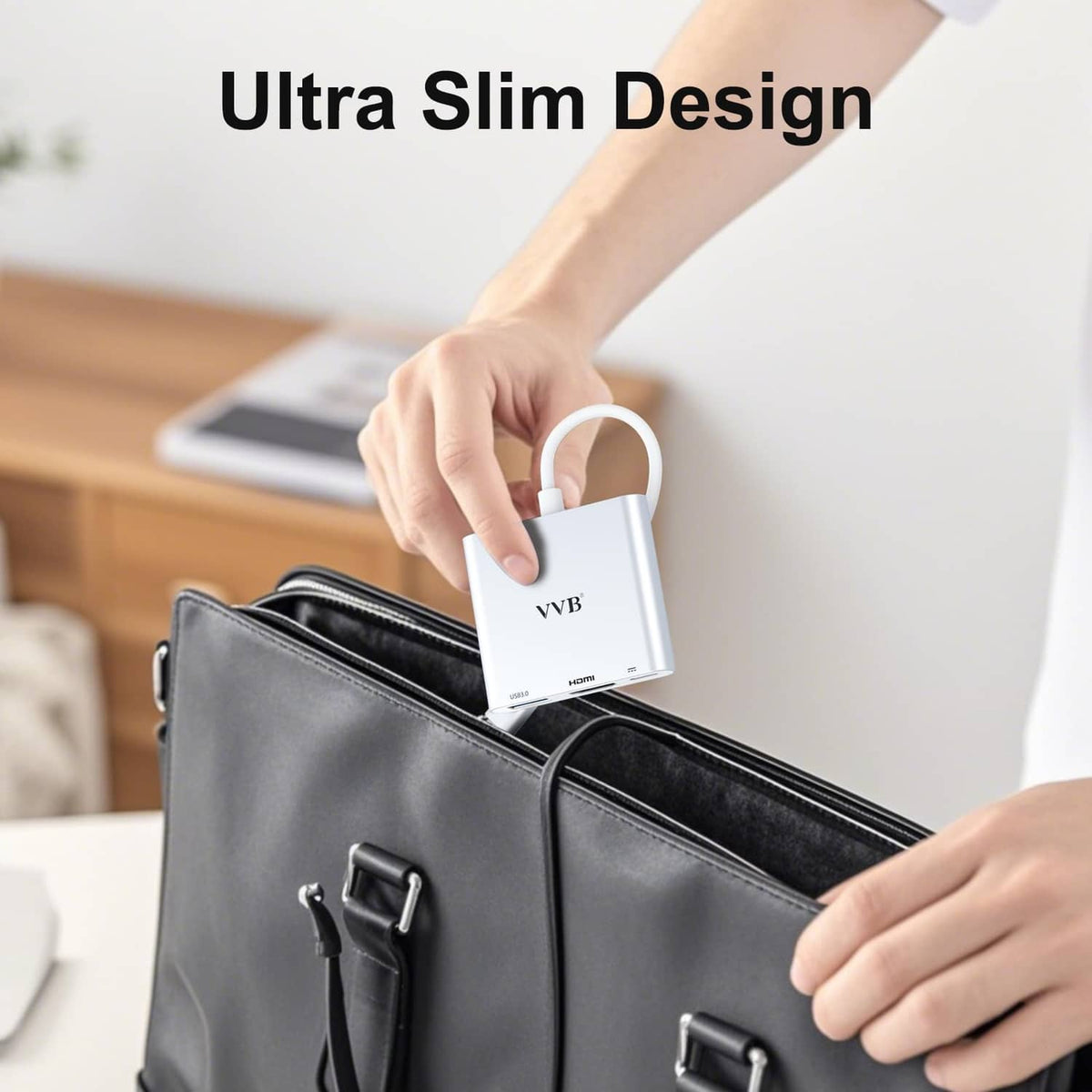 Slim silver USB-C adapter with attached cable, held above a carry bag.