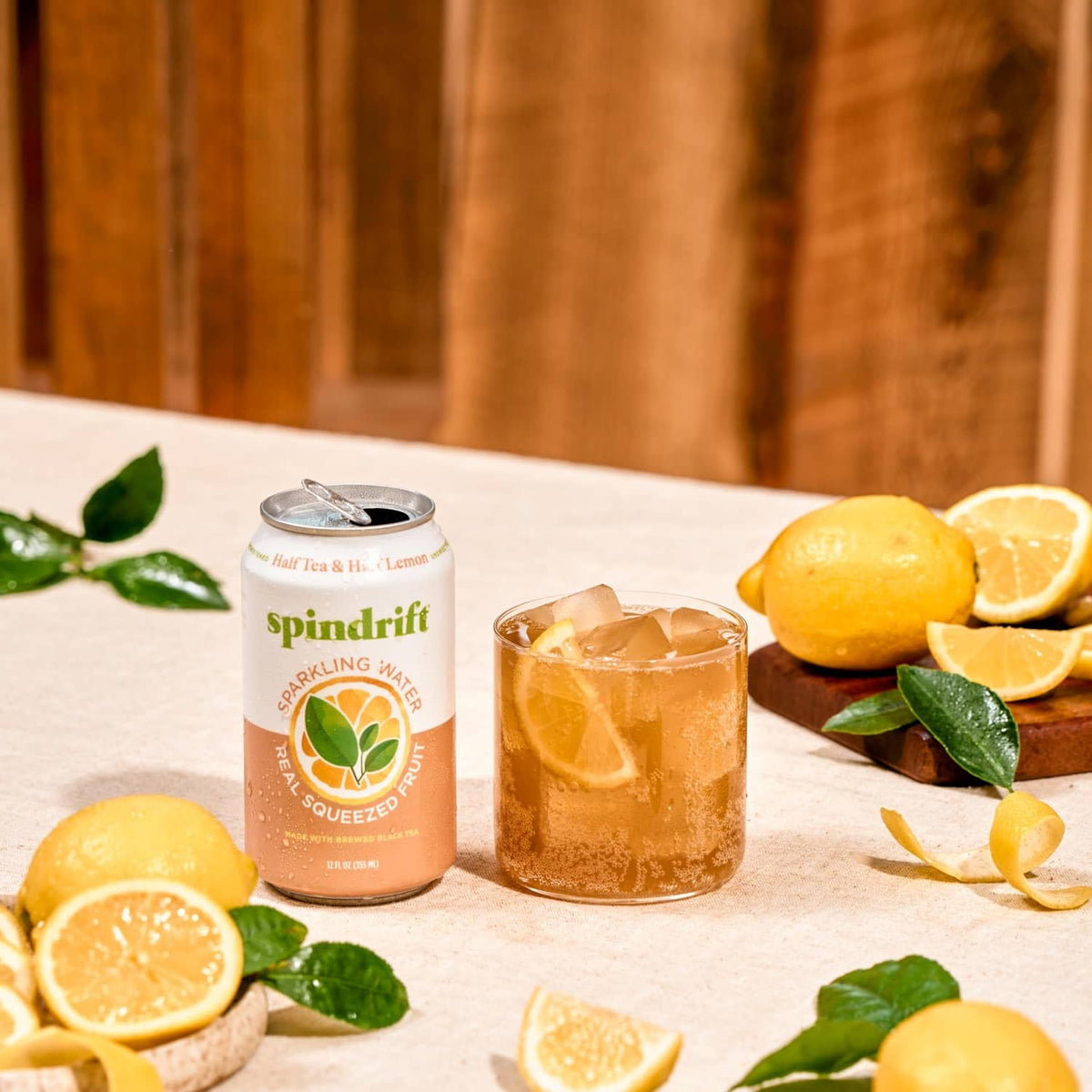 Half tea & half lemonade sparkling water can with iced drink and lemon slices
