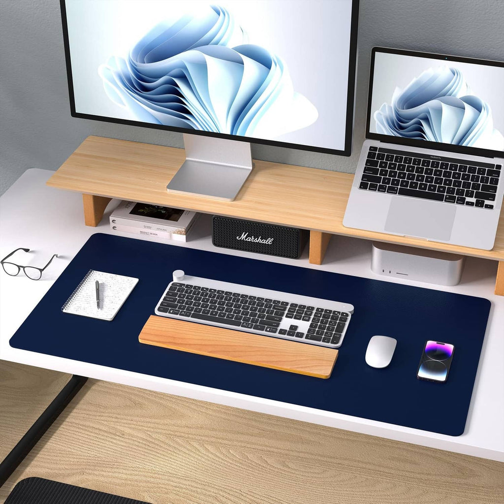 Dark blue desk pad protector covering a desk with laptop keyboard and mouse