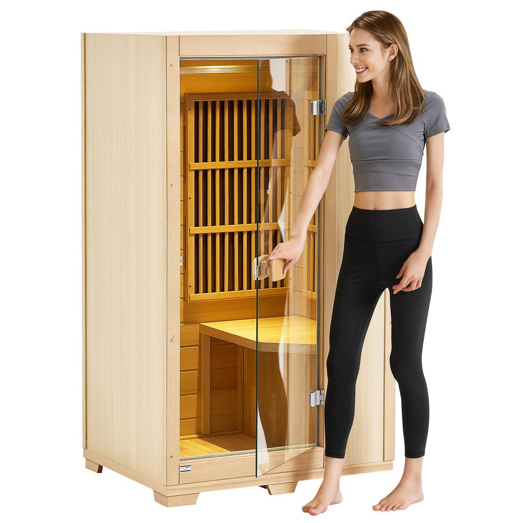 Light wood one-person far infrared sauna with clear glass door; woman stepping out