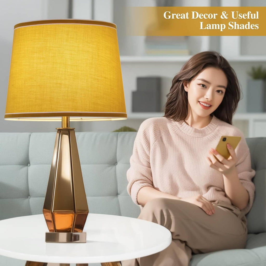 Yellow drum table lamp shade with white trim on a brass base