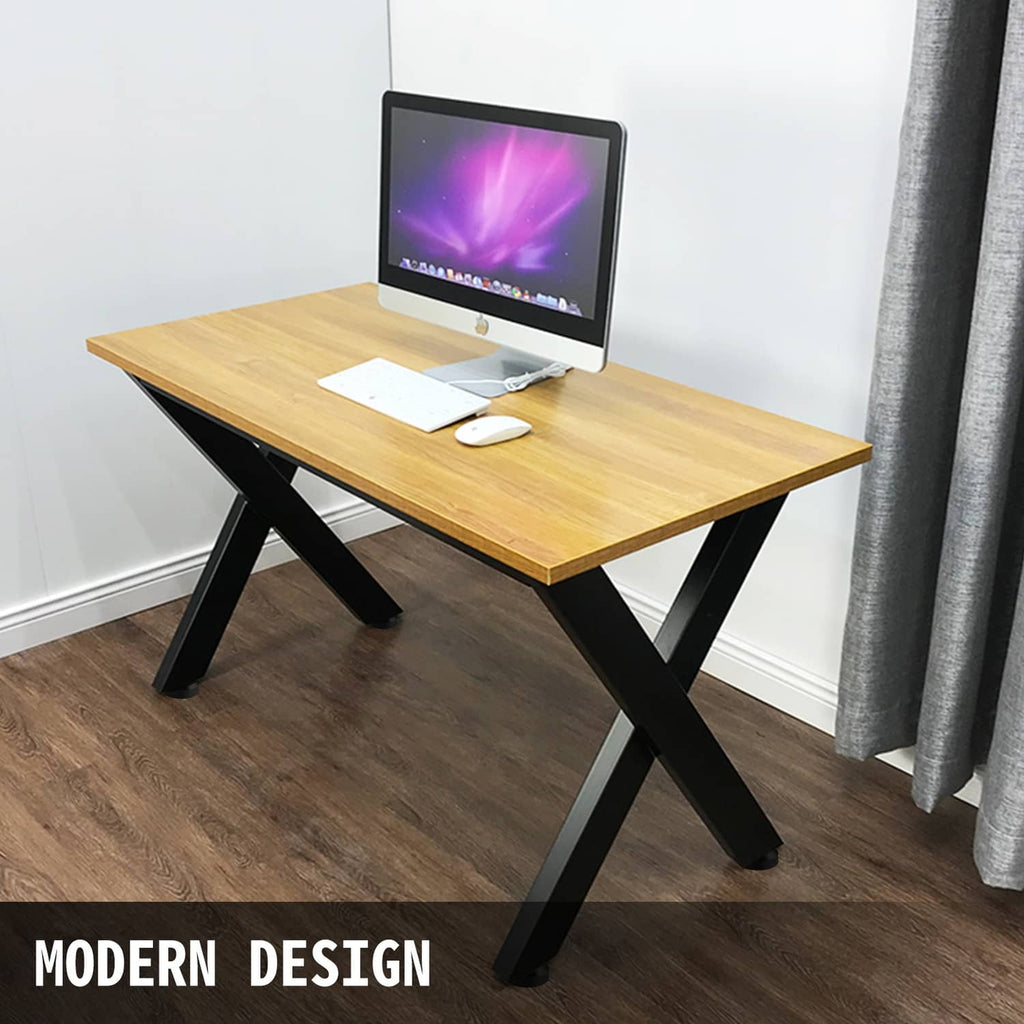 Black X-frame metal desk table legs supporting a light wood tabletop