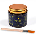 Gold leaf sealer jar with gold-toned lid, labeled, plus orange flat brush