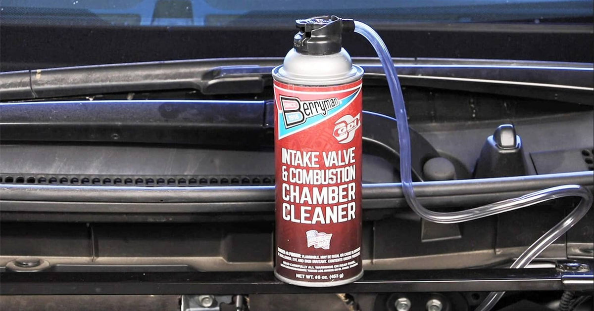 Intake valve & combustion chamber cleaner bottle with attached hose in engine bay