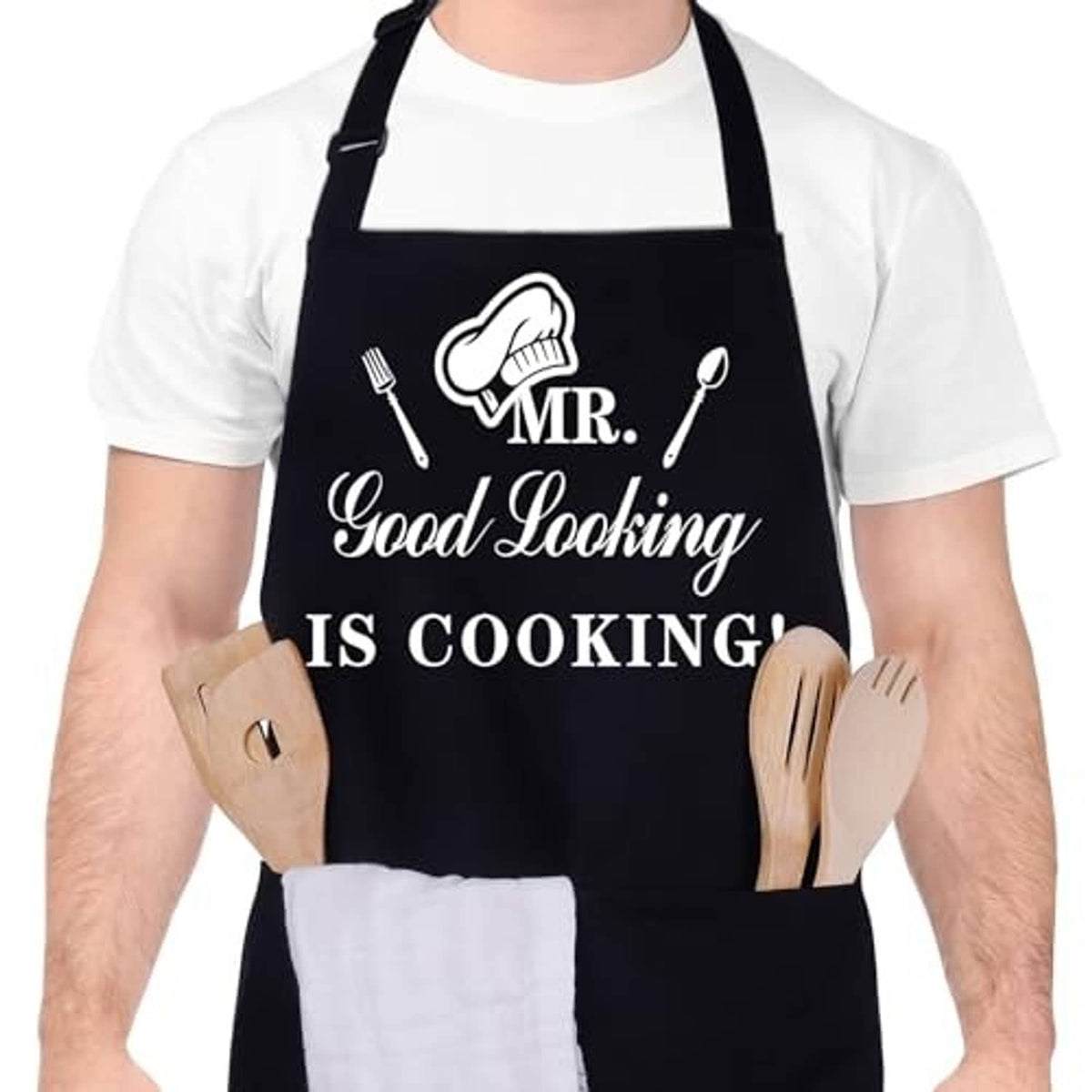 Black apron with “MR. Good Looking IS COOKING!” design, worn over white shirt