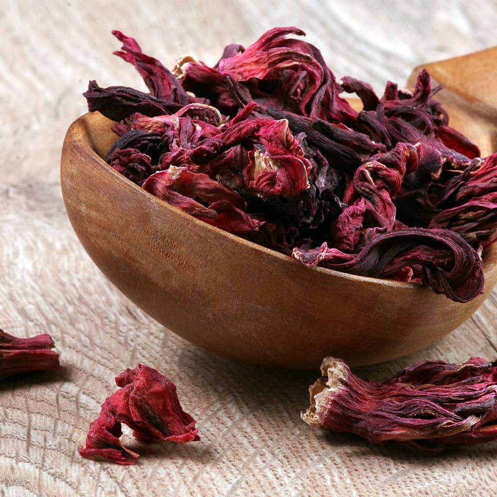 Bowl of dried hibiscus petals and whole flowers in burgundy