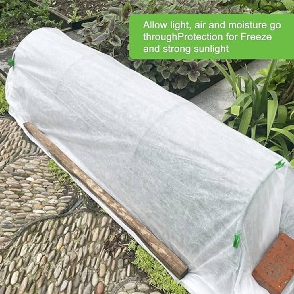 White long plant cover draped over outdoor plants along a walkway