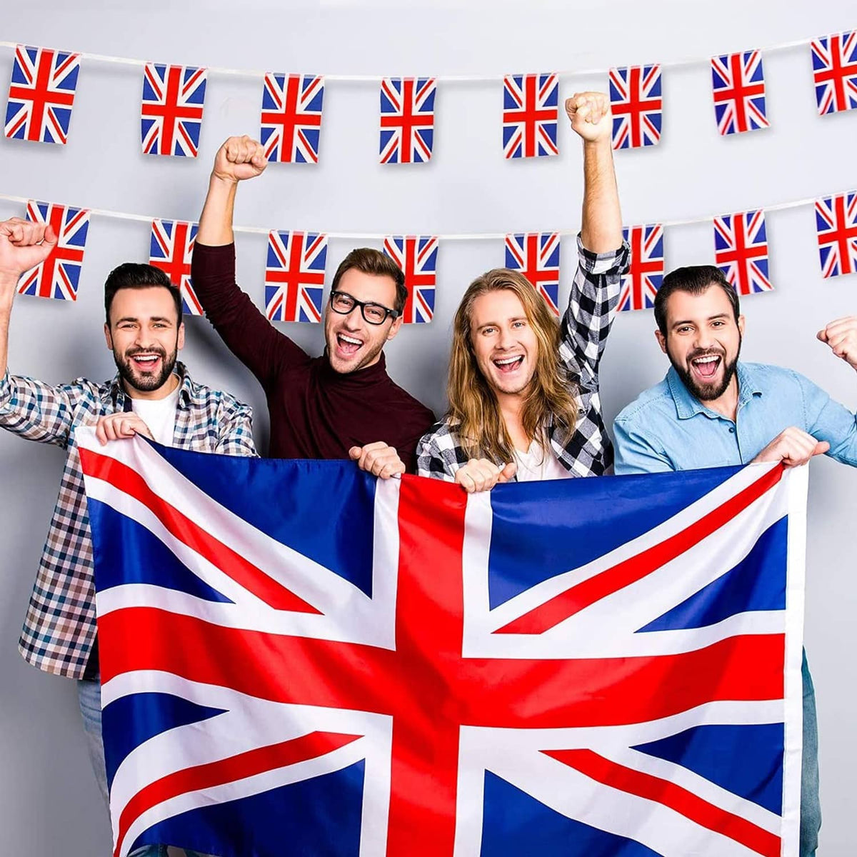 Union Jack outdoor flag held up by group, red center cross on blue with white stripes