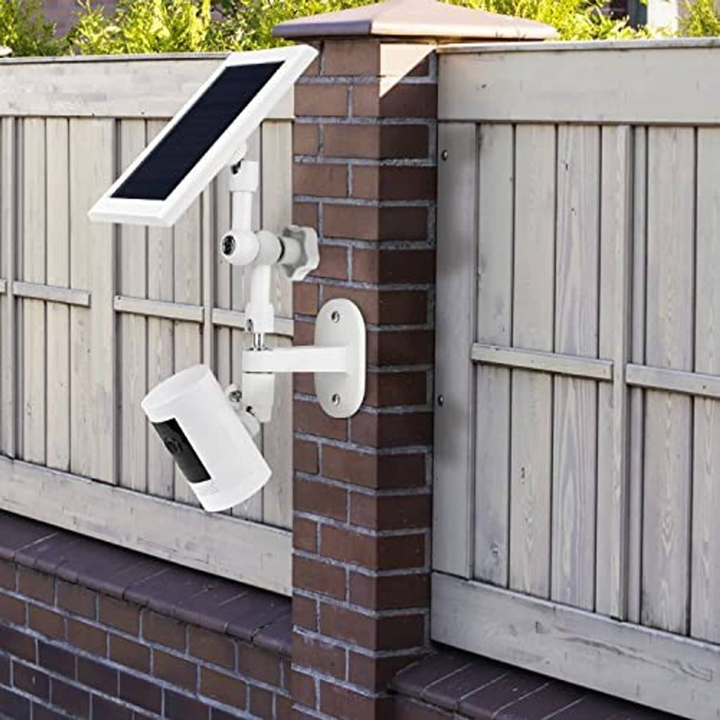 White wall mount kit installed on brick wall with solar panel and camera mount