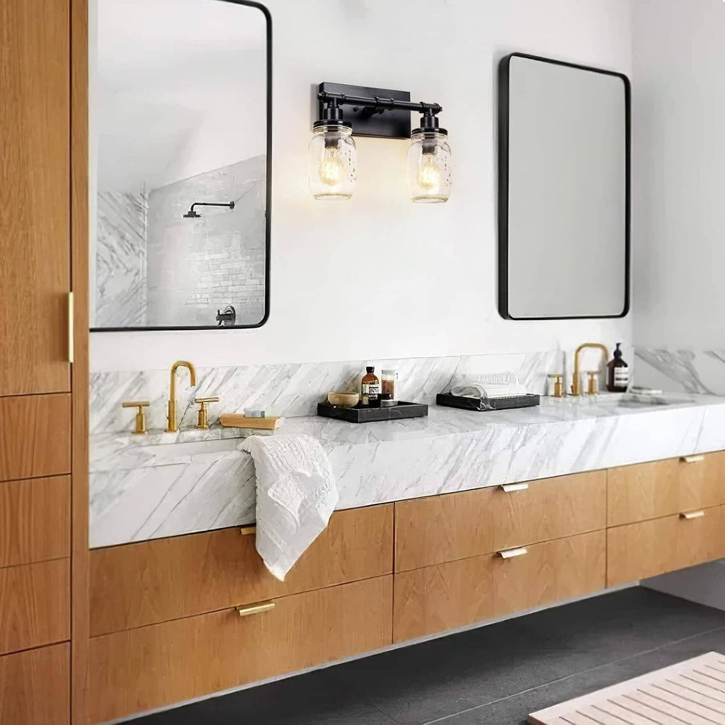 Black 2-light vanity light with two clear mason-jar shades over bathroom counter