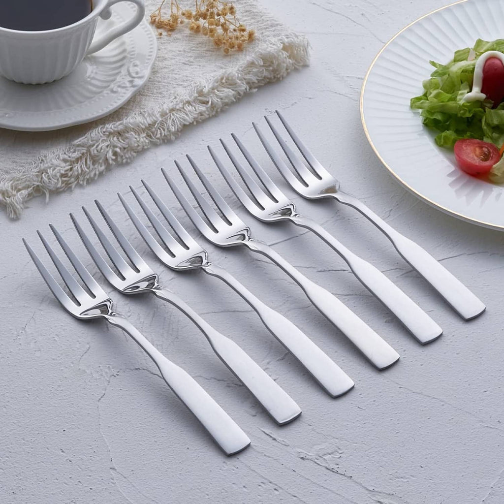 Row of stainless steel 3-tine dinner forks, polished silver, matching handles