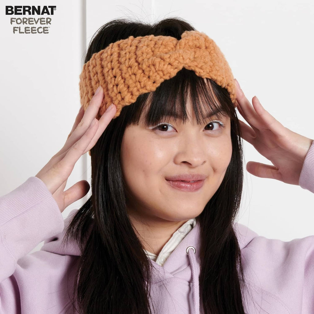 Brown chunky knit headband worn over dark hair with rounded textured stitches