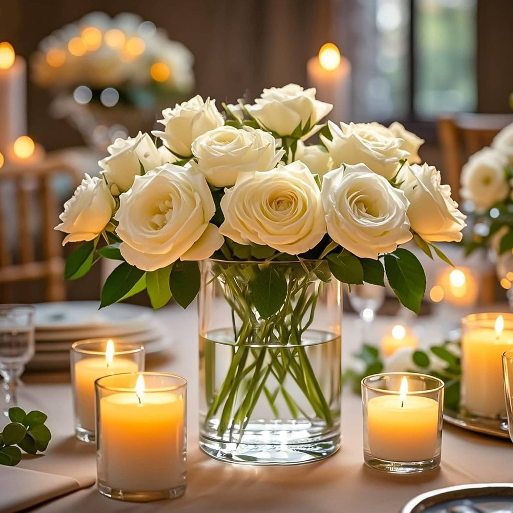 Clear glass cylinder vase with white roses and candles around it