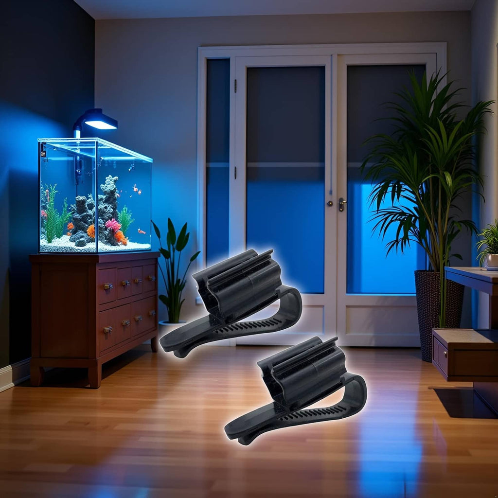 Two black aquarium hose clips near a fish tank, curved ridged mounting holders