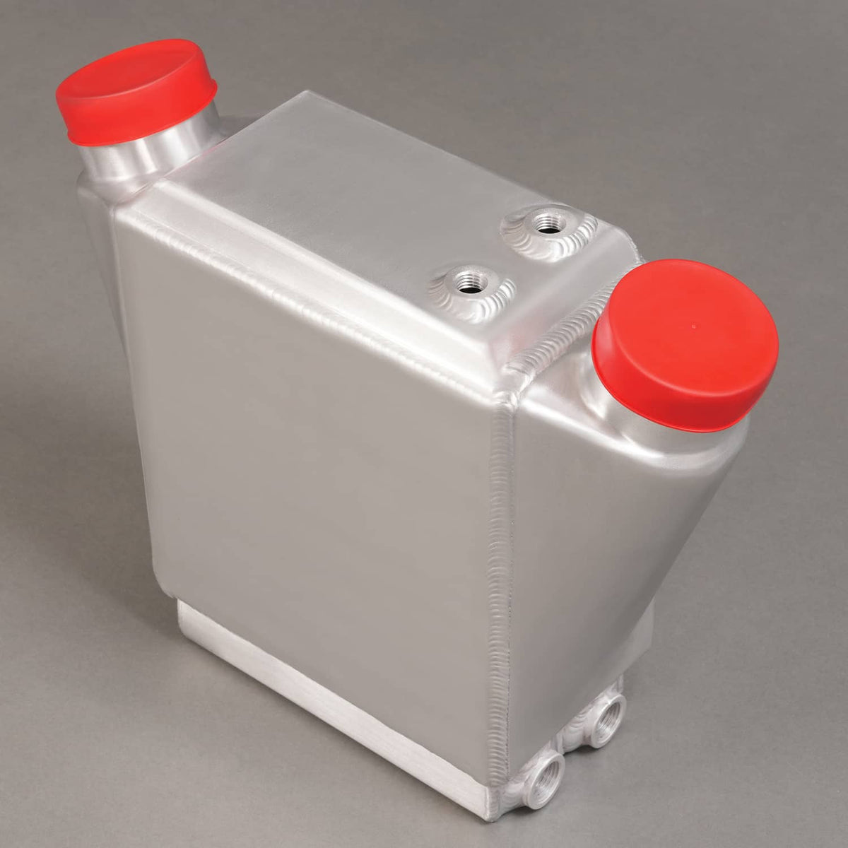 Aluminum intercooler with red end caps, top mounting holes, and side inlet pipes.